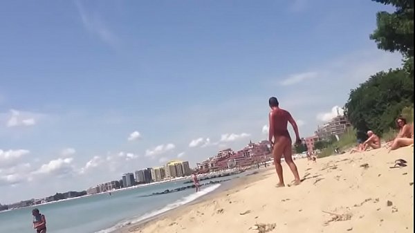 Macho sai da água com o cassete duro na frente de outros banhistas.